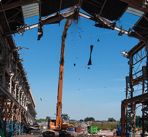 Digger demolishing building