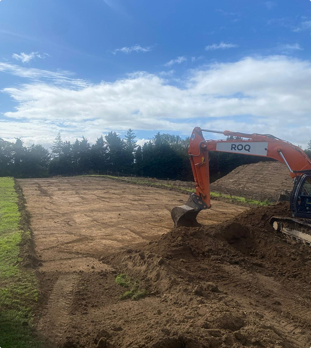 Digger stripping top soil